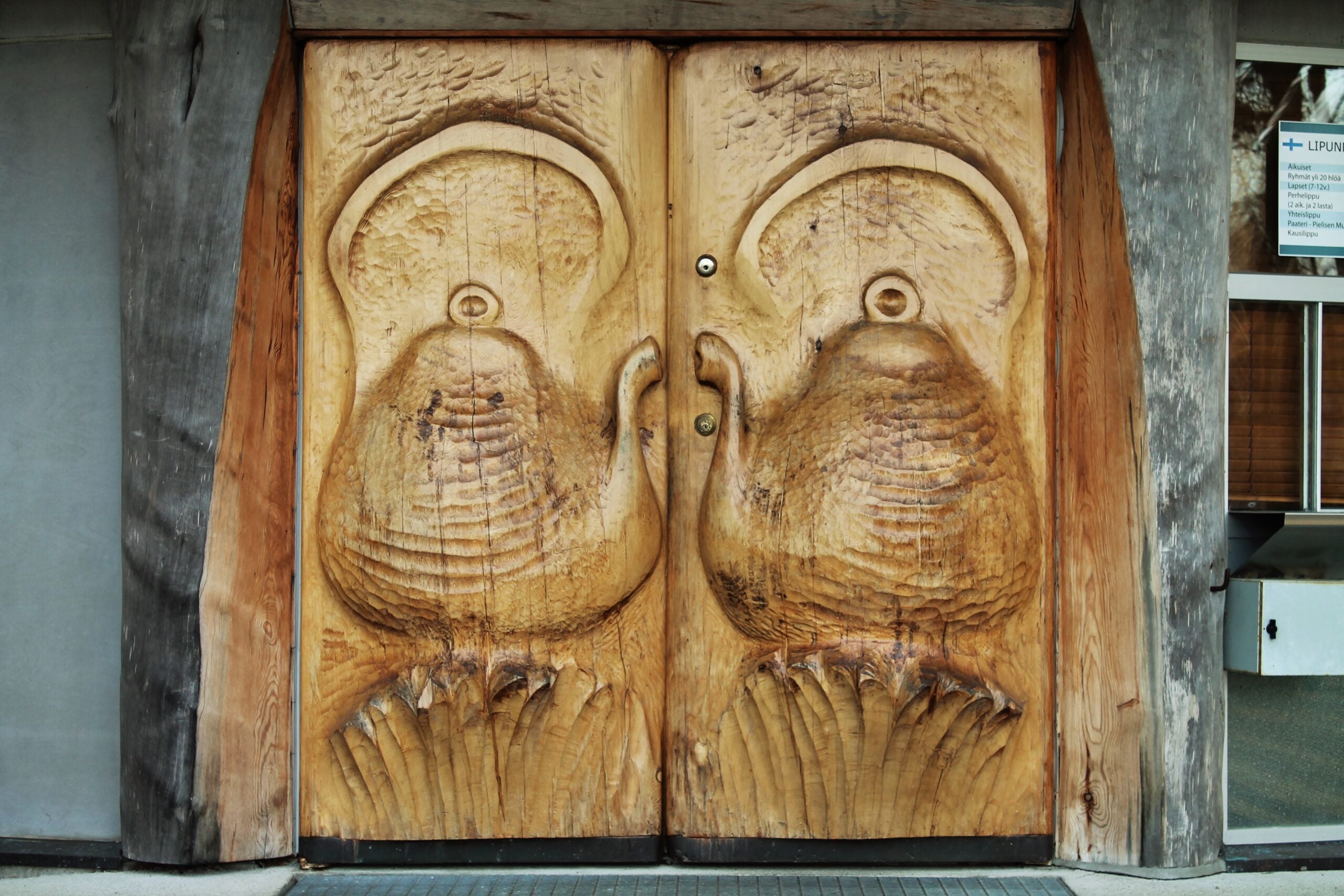 Paaterin kahvilan ovissa olevat puusta veistetyt kahvipannut