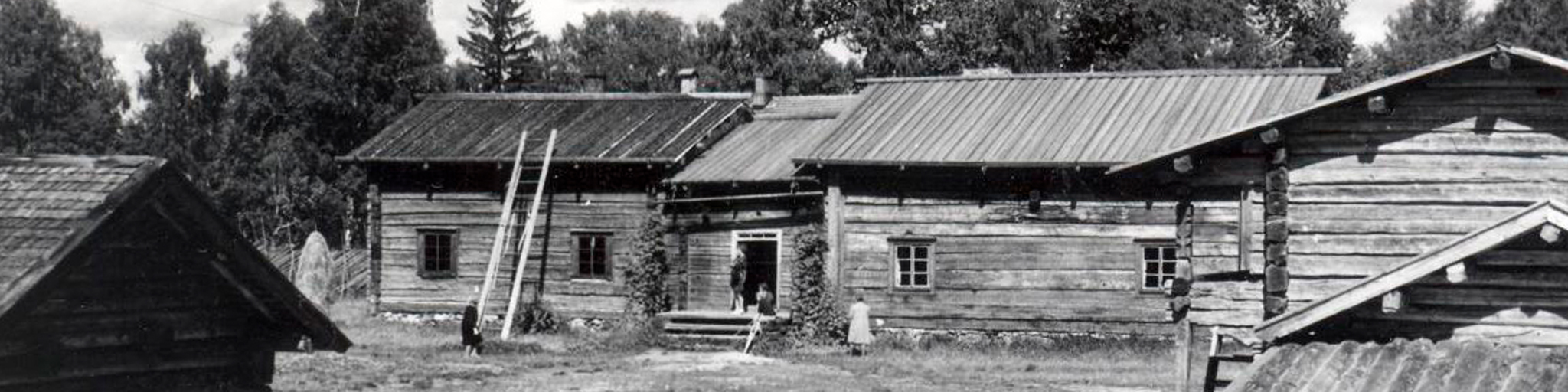 Vanha mustavalkoinen valokuva Pielisen museon ulkomuseoalueen rakennuksista