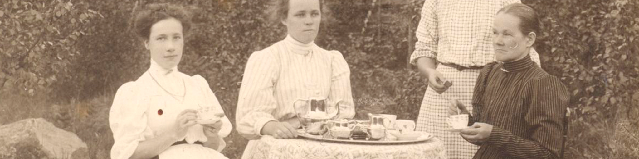 Naiset istuvat kahvilla vanhassa mustavalkoisessa valokuvassa