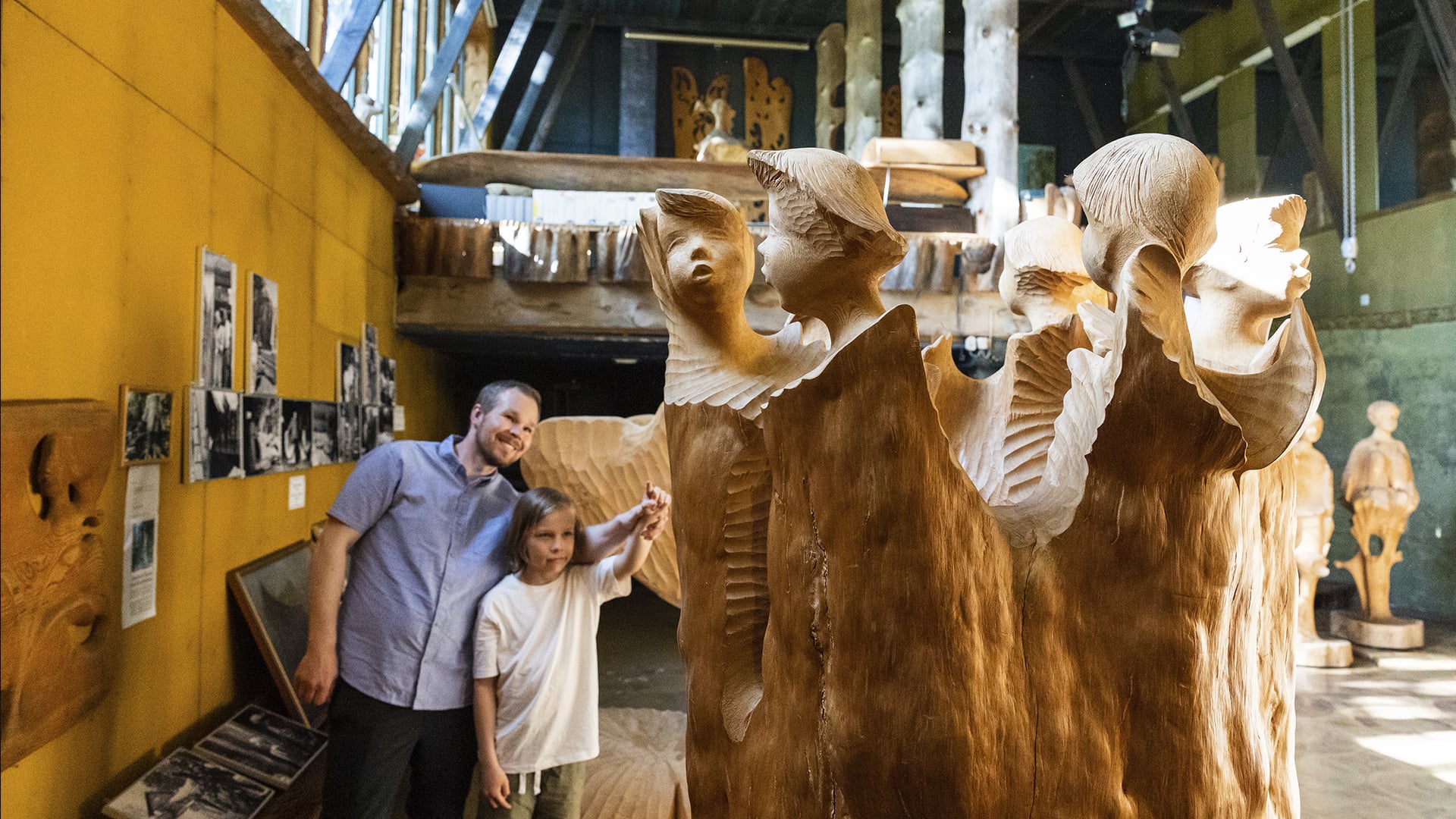 Isä ja lapsi katselevat Eva Ryynäsen veistoksia