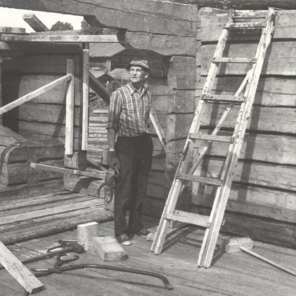 Kirvesmies Nestori Koistinen pystyttämässä jyvämakasiinia